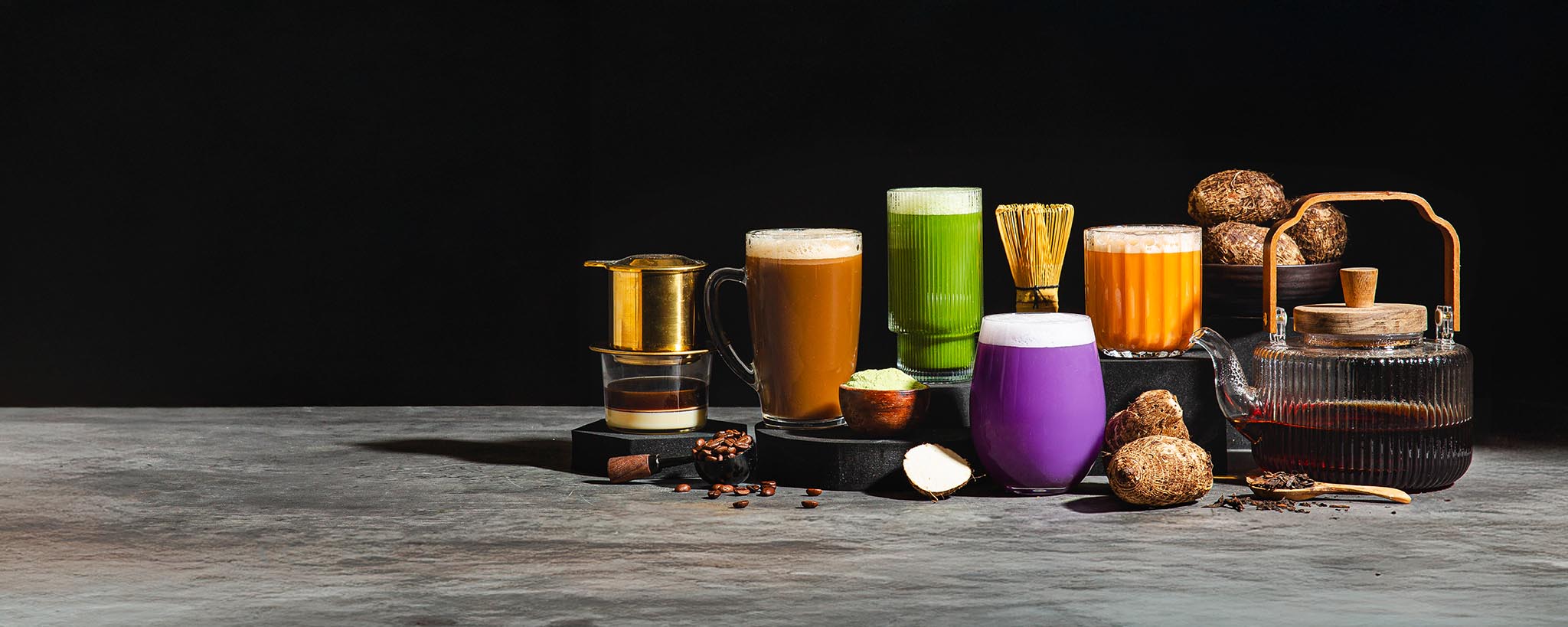 Header line up of colorful mixed protein powder drinks in various glasses.