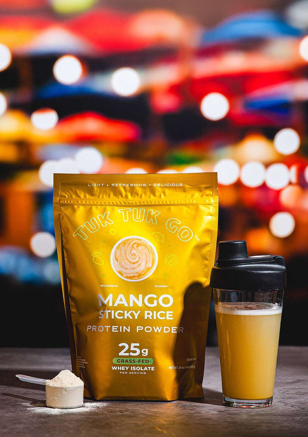 Mango sticky rice protein powder in pouch with mixed protein drink in glass.
