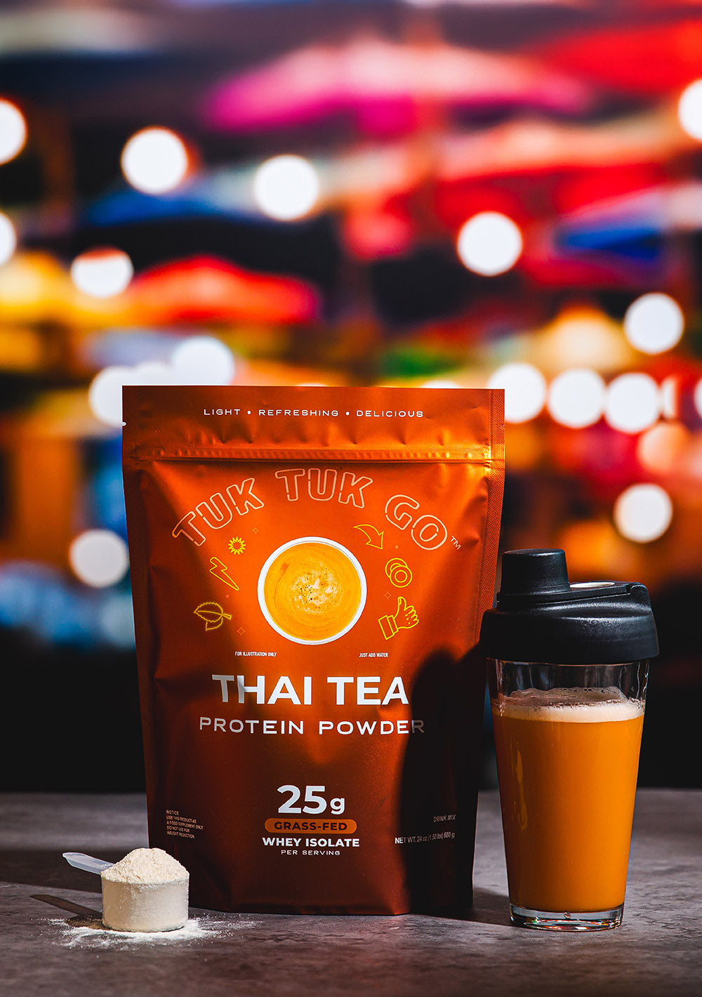 Thai Tea protein powder in pouch with mixed protein drink in glass.