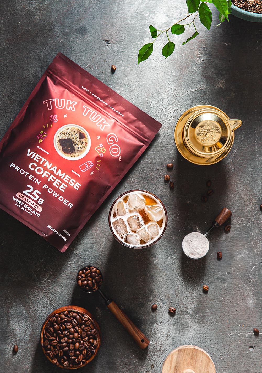 Vietnamese Coffee protein powder pouch top down shot with glass of coffee.