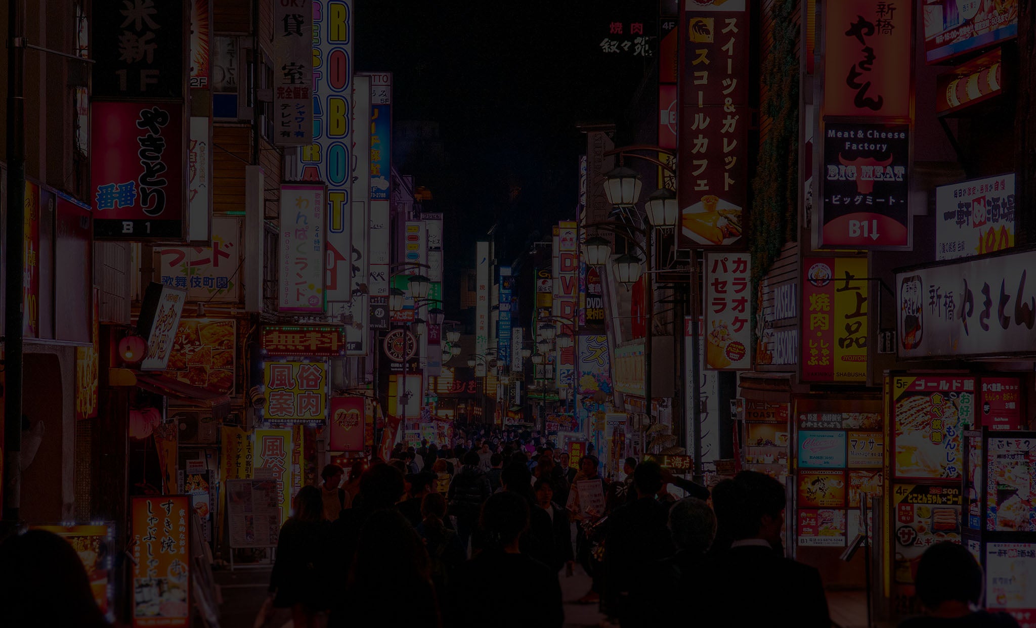 Website Background: a busy square full of brightly-lit billboards and advertisements.